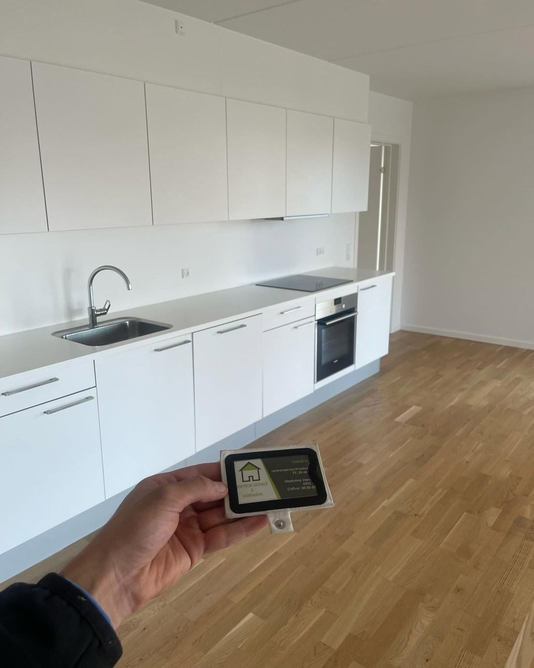 Hvidt køkken med integreret ovn og vask, klar til renovering eller opgradering. Perfekt til moderne.